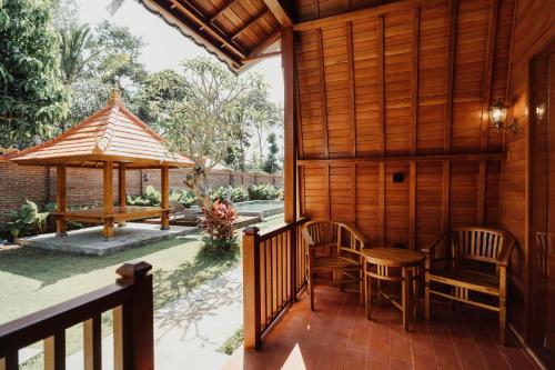 a porch of a house with chairs and a gazebo at Maha Villa Kelating in Krambitan