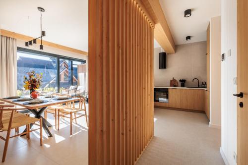 a kitchen and dining room with a table and chairs at Stylchyn Park - Czorsztyn Exclusive - by Upstairs in Kluszkowce