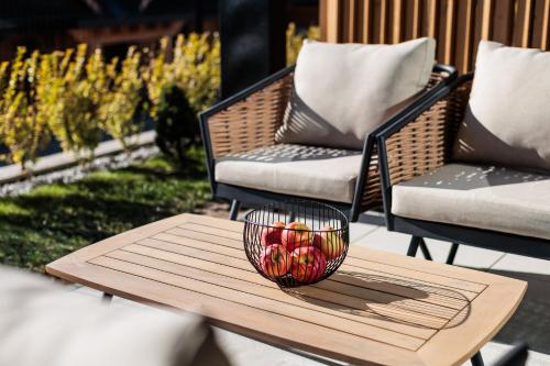 a bowl of fruit on a wooden table on a patio at Stylchyn Park - Czorsztyn Exclusive - by Upstairs in Kluszkowce