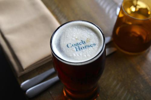 a glass of beer sitting on a table at Coach & Horses Dersingham in Dersingham
