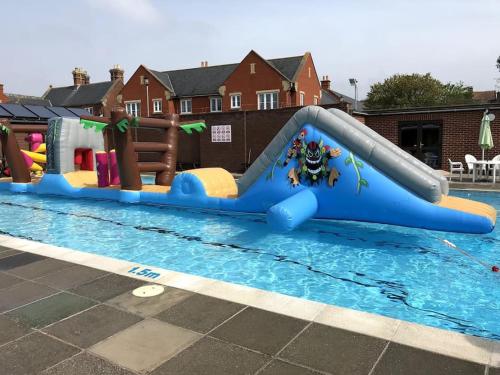 a pool with a slide in a swimming pool at Stunning Town house with parking, fire, games room in Topsham