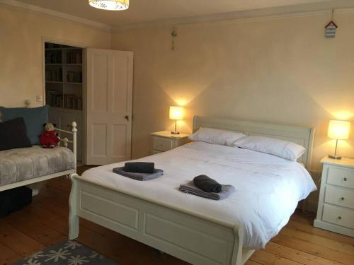 a bedroom with a white bed with towels on it at Stunning Georgian Town house with Open Fire, Piano & Games Room in Topsham