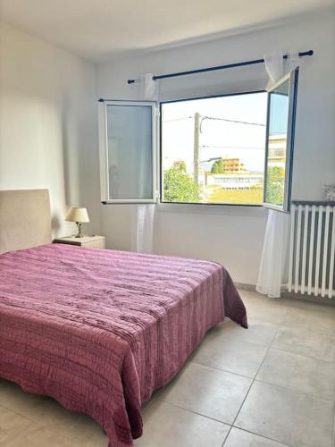 une chambre avec un lit violet et une fenêtre dans l'établissement Charmant T3 Rénové Proche Mer, Aéroport et Gare !, à Saint-Laurent-du-Var