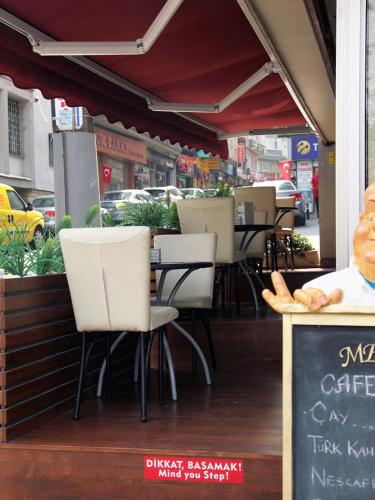 a restaurant with white chairs and tables on a street at Hotel Artiç in Bursa