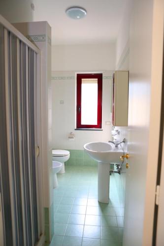 a bathroom with two sinks and a toilet and a window at Residence Soleluna in Praia a Mare