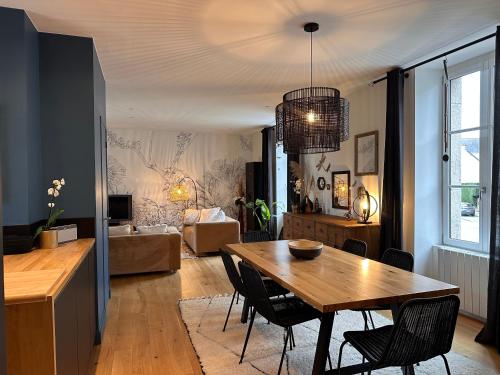 une salle à manger et un salon avec une table et des chaises dans l'établissement Les libellules, à Lanvallay