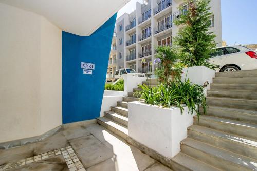 a set of stairs with potted plants in front of a building at Hillock Residence Apartments in Marsalforn