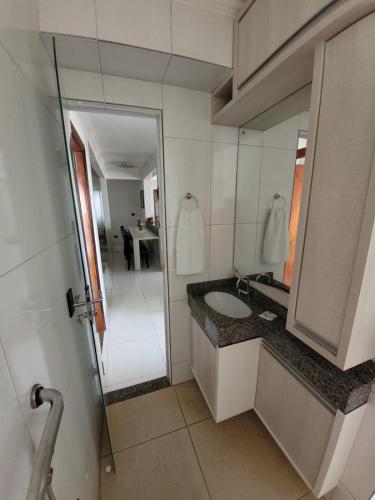 a bathroom with a sink and a mirror at Hotel Globo in Cianorte