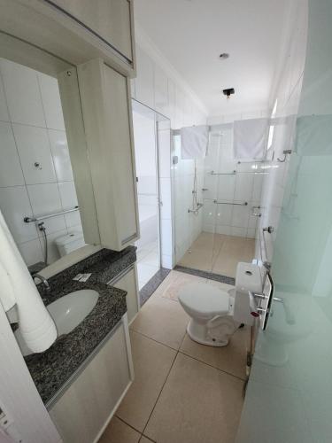 a bathroom with a toilet and a sink and a shower at Hotel Globo in Cianorte
