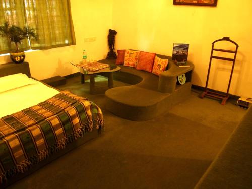 a bedroom with a bed and a couch and a table at The Red House in Ooty