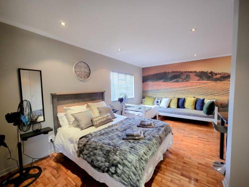 Un dormitorio con una cama grande y un sofá. en Royal Boland, en Paarl