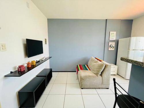 サンルイスにあるAp Vip 804, localização maravilhosa em São Luís.のリビングルーム(椅子、テレビ付)