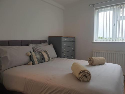 a bedroom with a bed with two towels on it at Coates Road-Spacious 4 bed home-near RD&E-parking in Countess Wear