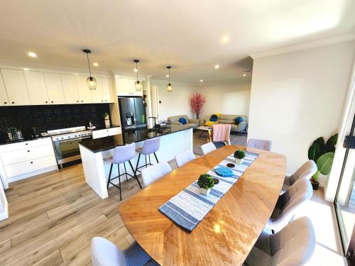 a kitchen and dining room with a wooden table and chairs at The Cozy Oasis in Napier