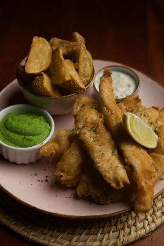 a plate of fried food with dipping sauce and chips at Daffodil Restaurant & Holiday Resort in Unawatuna