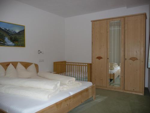 a bedroom with a bed and a wooden cabinet at Gasthof Gemse in Planol