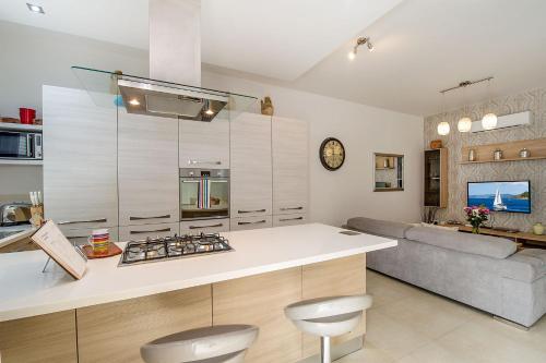 a kitchen with a white counter top and a couch at Hillock Residence Apartments in Marsalforn