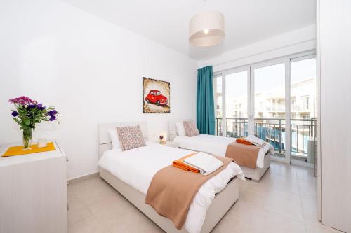 a bedroom with two beds and a window at Hillock Residence Apartments in Marsalforn