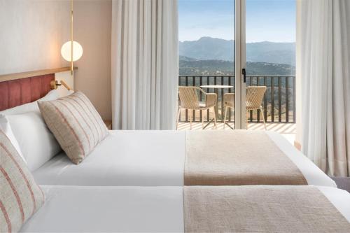 a bedroom with a bed with a view of a balcony at Catalonia Reina Victoria in Ronda