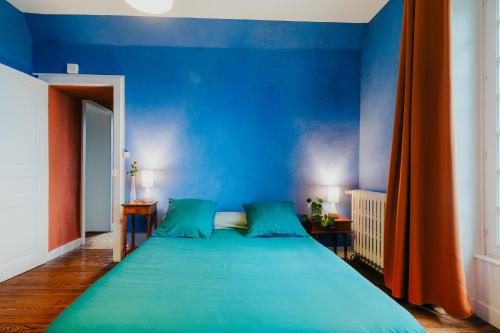 a blue bedroom with a large bed with blue walls at Villa La Côte du Chat in Hédé