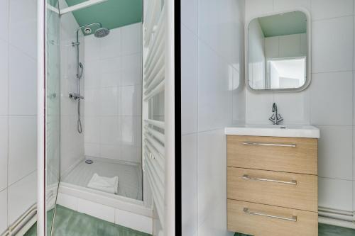 une salle de bain avec une douche, un lavabo et un miroir dans l'établissement Heart of Montmartre l Sacré-Coeur at 10min, à Paris