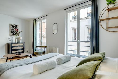 une chambre avec un grand lit et une fenêtre dans l'établissement Heart of Montmartre l Sacré-Coeur at 10min, à Paris