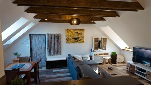 a living room with a blue couch and a tv at Apartman Vulcano in Zvolen