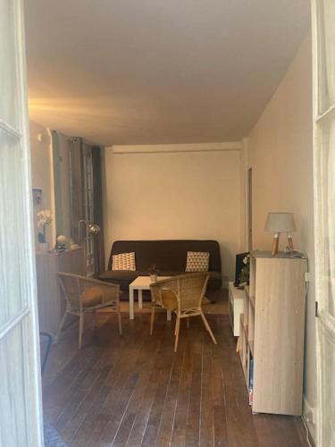 un salon avec un canapé, une table et des chaises dans l'établissement Appart charmant à Montmartre, à Paris