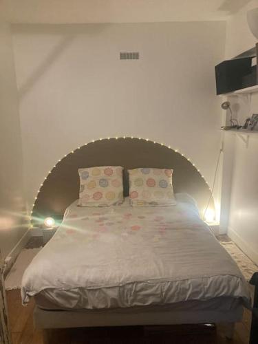 un lit avec deux oreillers dessus dans l'établissement Appart charmant à Montmartre, à Paris