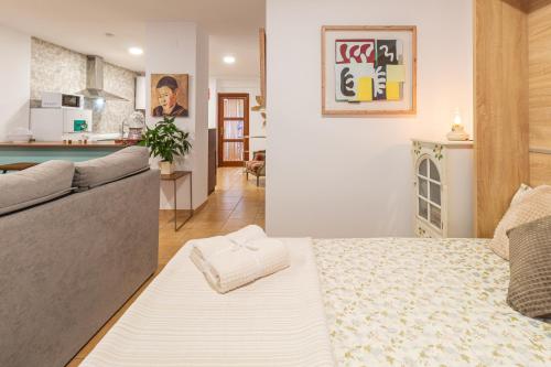 a room with a bed and a couch and a kitchen at La petite maison de Nadette 2 in Gandía