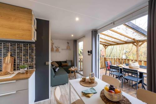 une cuisine et un salon avec une table et une salle à manger dans l'établissement Slow Village Les Ponts de Cé, à Les Ponts-de-Cé