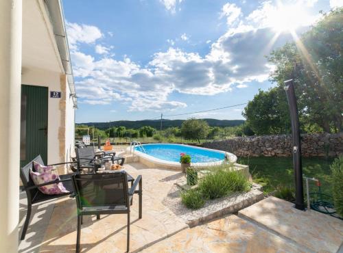un patio con piscina, mesa y sillas en Serene Retreat Holiday Home with Pool, en Veliki Broćanac