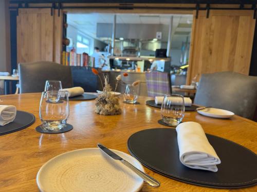 a wooden table with black plates and glasses on it at Winteringham Fields in Winteringham
