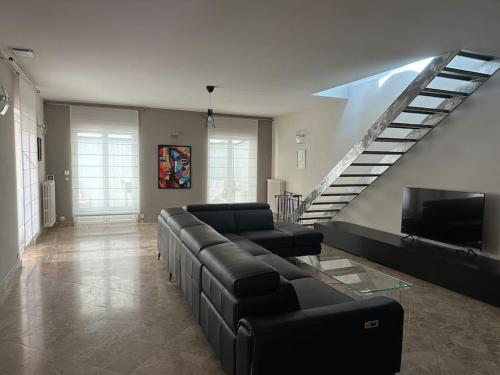un salon avec un canapé et un escalier dans l'établissement Gorgeous 5 bedroom villa with air con, heated pool and garden for 12, à Villemoustaussou
