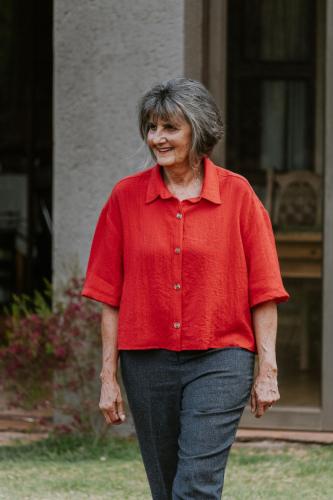an older woman walking in front of a house at White Linen Guesthouse in Tierpoort