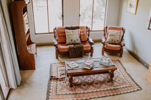 a living room with two chairs and a coffee table at White Linen Guesthouse in Tierpoort