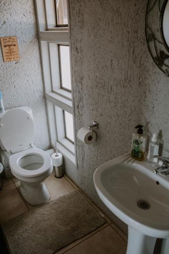 a bathroom with a toilet and a sink at White Linen Guesthouse in Tierpoort