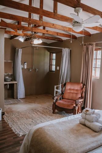 a bedroom with a bed and a chair in it at White Linen Guesthouse in Tierpoort