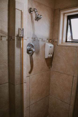 a shower with a shower head in a bathroom at White Linen Guesthouse in Tierpoort