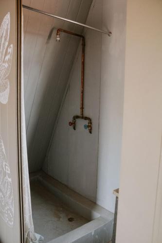 a shower in a room with a shower curtain at White Linen Guesthouse in Tierpoort