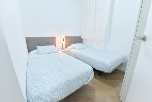 two beds in a small room with white walls at Nuevo! Apartamento Premium junto a Sevilla | B in La Algaba