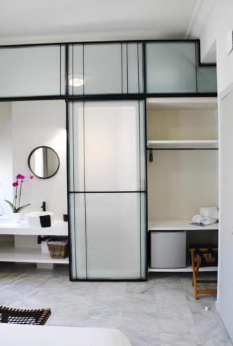 a room with sliding glass doors and a sink at OIKO MINI SUITES in Ermoupoli