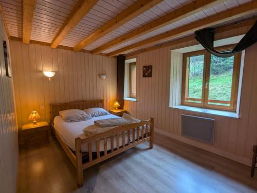 une chambre avec un lit dans une pièce avec une fenêtre dans l'établissement Les Bruyères - 15 pers - full nature, à Xonrupt-Longemer