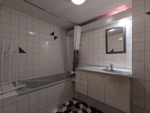 une salle de bain avec un lavabo, une baignoire et un miroir dans l'établissement Les Bruyères - 15 pers - full nature, à Xonrupt-Longemer