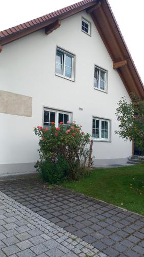 a white house with some flowers in front of it at Ferienwohnung Maria Waldblick 95 qm, in Burtenbach