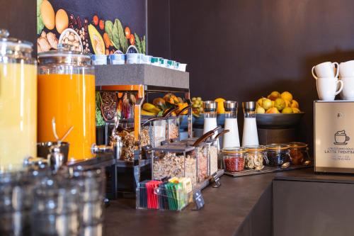 a counter with food and drinks on top of it at Hi Hotels Trento - Wellness & Spa Adults Only in Trento