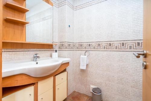 bagno con lavandino e parete piastrellata di Villa Alvor ad Alvor