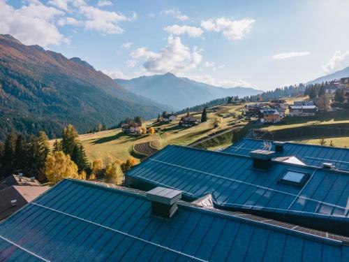 an overhead view of roofs of buildings in a valley at mySHH in Vigo di Fassa