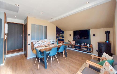 une cuisine avec une grande table et des chaises bleues dans l'établissement 1 Bedroom Nice Home In Docelles, à Docelles