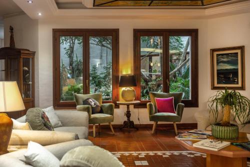 a living room with couches and chairs and windows at Hotel Stefania Boutique Hotel by the Beach in Olbia